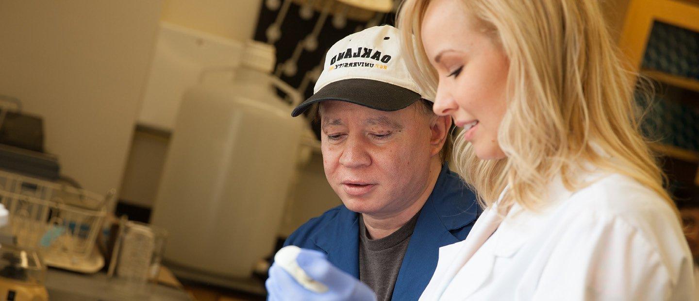 man in a hat 和 woman in a white coat working in a lab